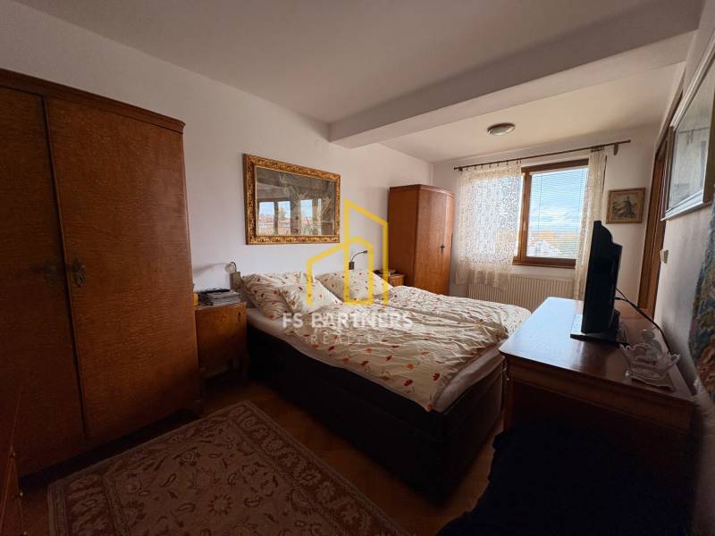 A bedroom in a 5 or more room apartment with carpet and wooden cabinets.