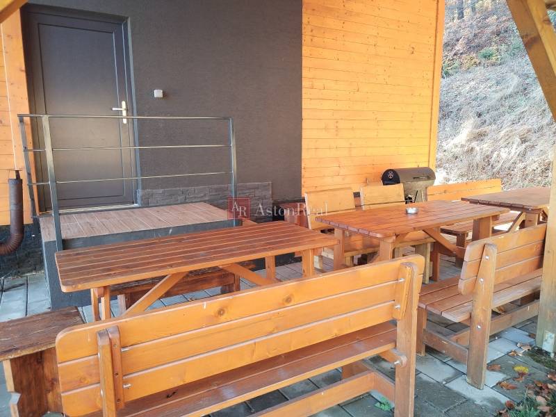 Cottage on Stráne in Martin with wooden benches and a grill on the terrace.