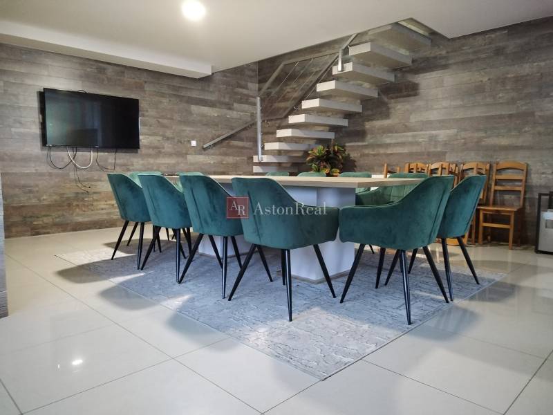 Dining table with turquoise chairs on a cottage floor with wooden decor.