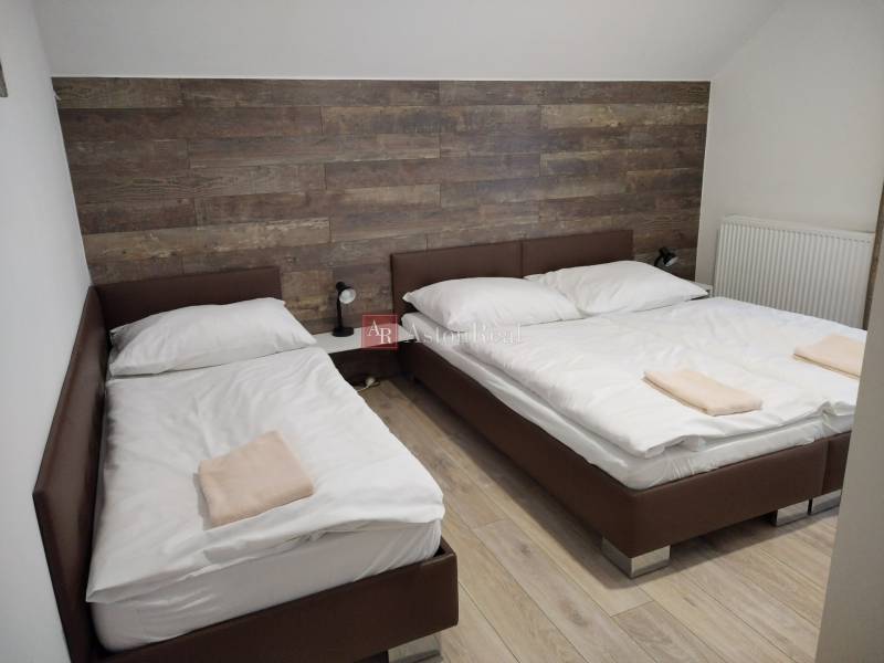 Double room in a cabin, floor with wood decor and wooden paneling.