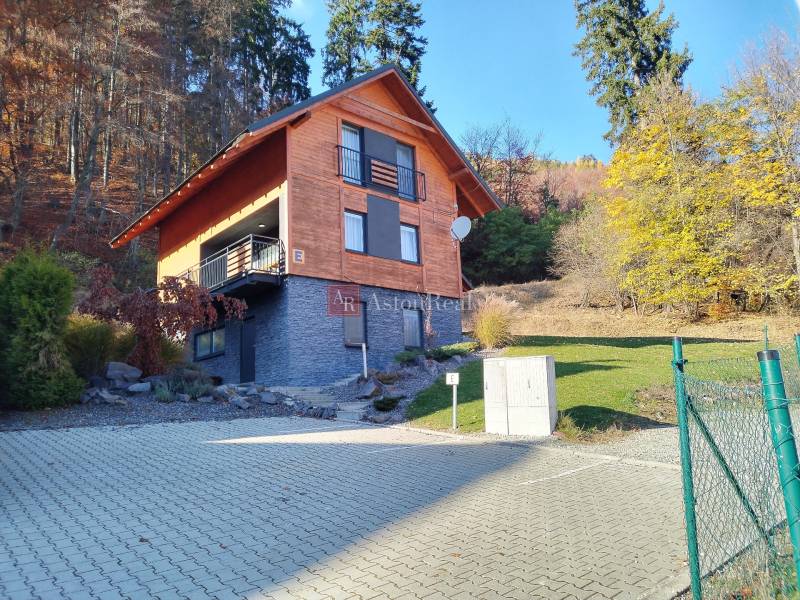 A cottage in an autumn setting on the Stráne in Martin, surrounded by trees and nature.