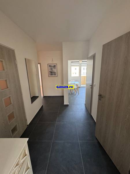 Entrance hallway in a 3-room apartment with dark flooring and light walls.