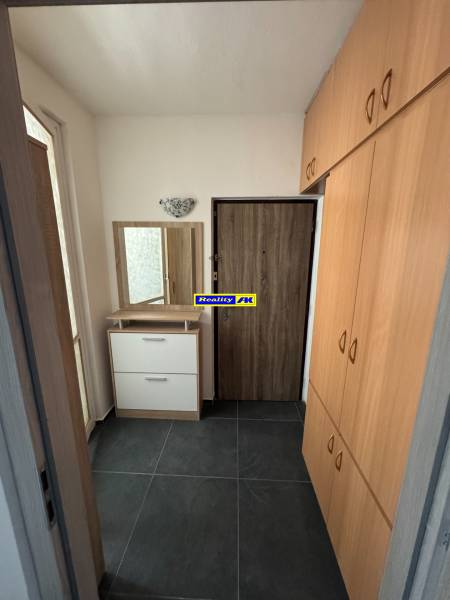 A hallway with dark tiles and a built-in wardrobe in a 3-room apartment.