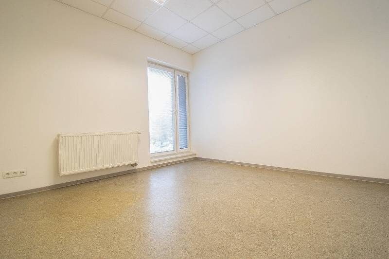 Empty office with a window, radiator, and floor.