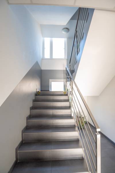 A staircase with a metal railing leads to a window in the offices.