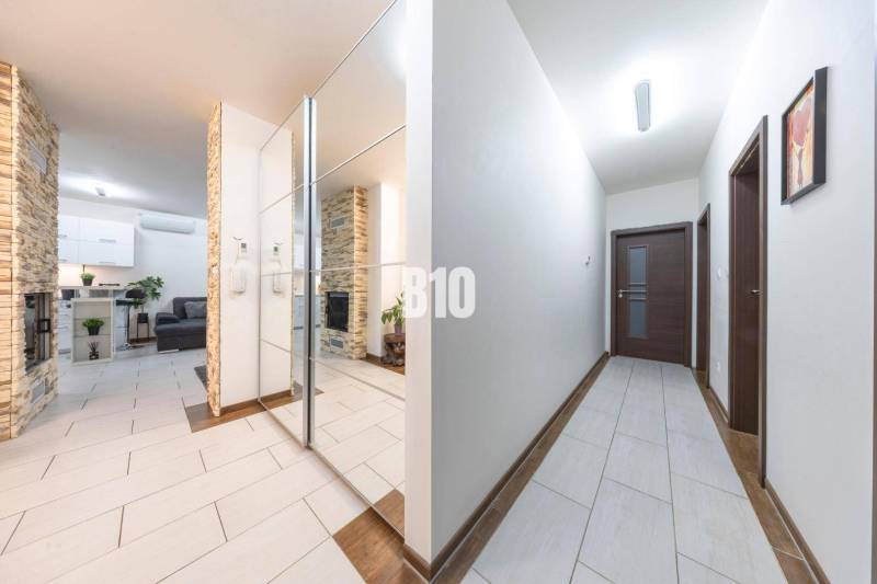 Hallway of a family house with tiles and a mirrored wall.