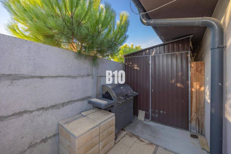 A garden in Most pri Bratislave with a grill and a wooden shelter by the family house.