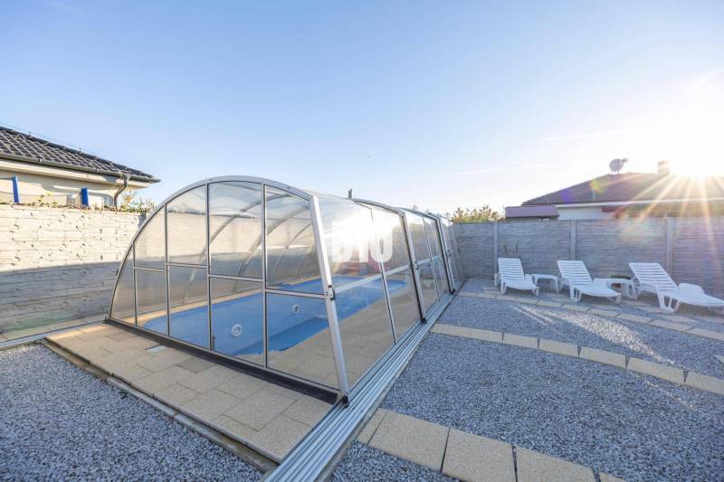 The garden of a family house in Most pri Bratislave with a swimming pool and loungers.