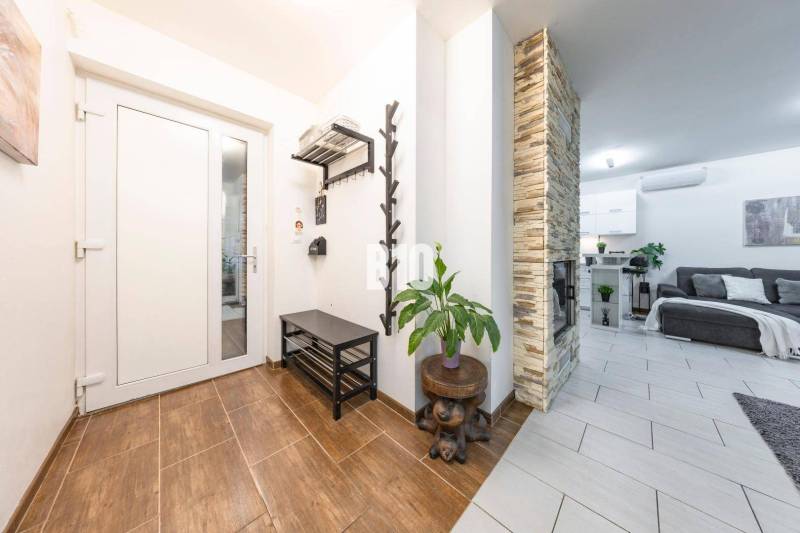 Interior of a family house with a wood-patterned floor, stone fireplace, and comfortable living room.