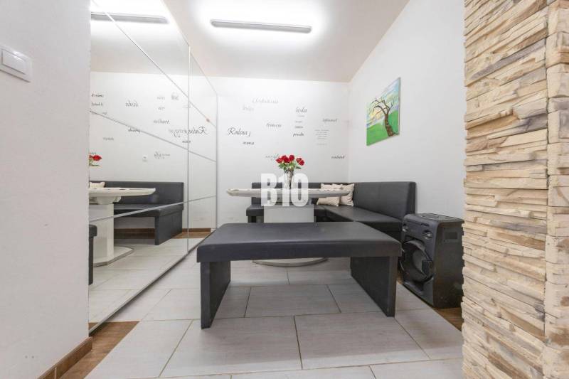 Interior of a family house with a seating area, mirrored wall, and decorative cladding.