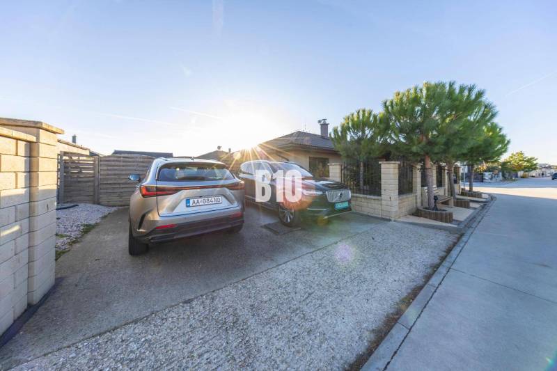 The courtyard of a family house in Most pri Bratislave with parking spaces and parked cars.