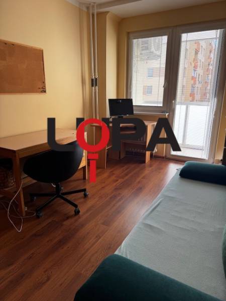 A workspace in a 3-room apartment with a wooden decor floor, bright room.