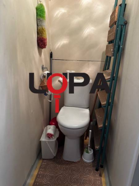 Toilet with a shelf and equipment in a 3-room apartment.