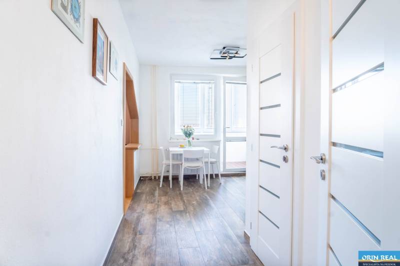 A hallway with wooden decor and a dining table in a 3-room apartment, luminous interior doors.