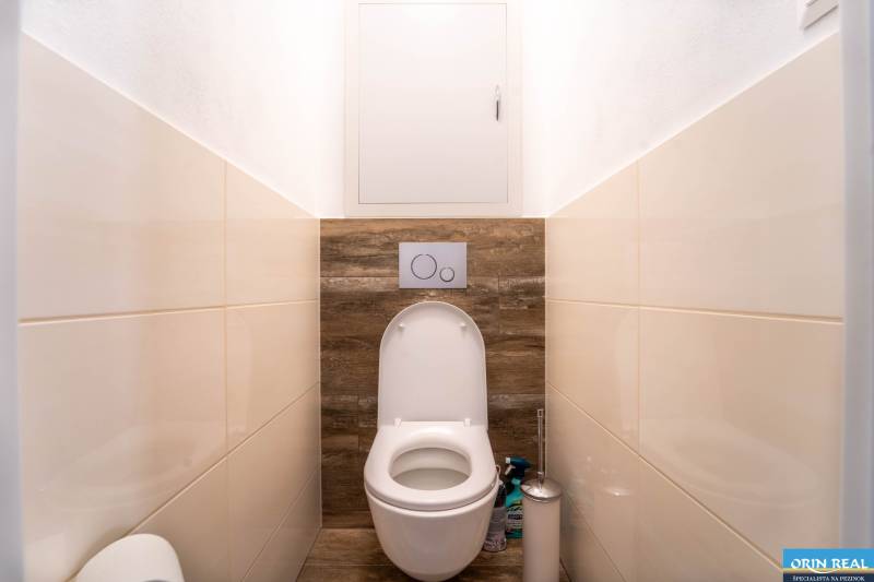 Bathroom with toilet and wooden decor flooring in a 3-room apartment.