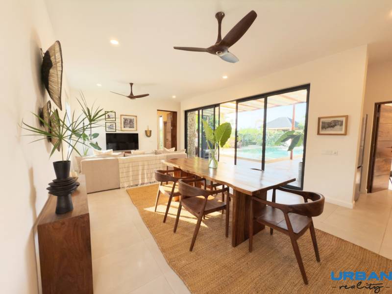 Interior with a dining table, wood-patterned flooring, and large glass doors, Home construction.