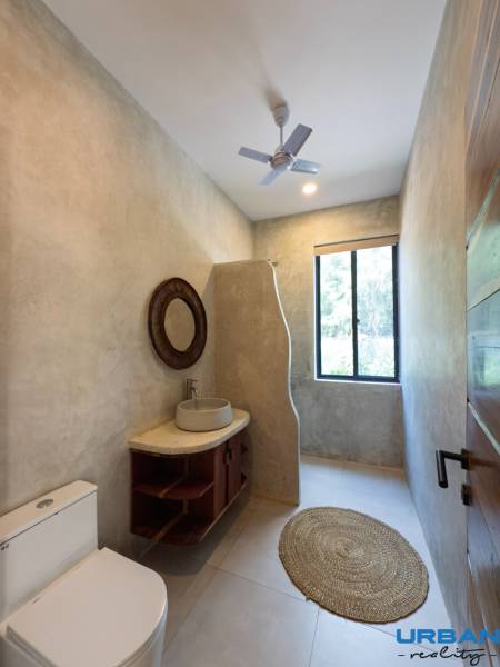 Bathroom with a sink, round rug, and fan. House construction.