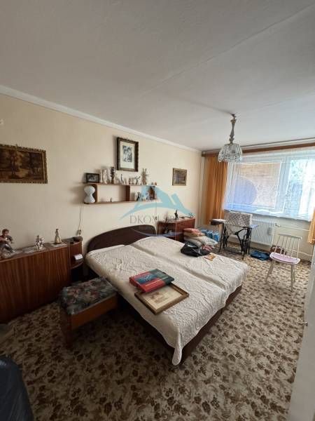 A room in a 3-room apartment with a crib, carpet, and furniture, decorations on the walls.