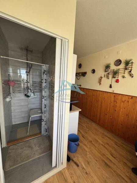Bathroom with a shower corner and a floor with a wooden decor in a 3-room apartment.