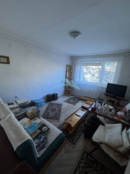 Living room in a three-room apartment with a wooden decor floor and furniture.