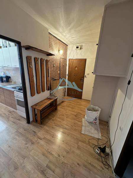 Interior of a 3-room apartment with a wooden decor floor and a wall-mounted coat rack.
