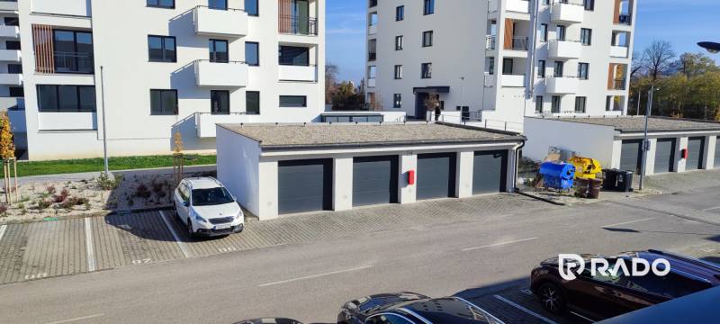 A view of Predmerského Street in Trenčín with an apartment building and parking.