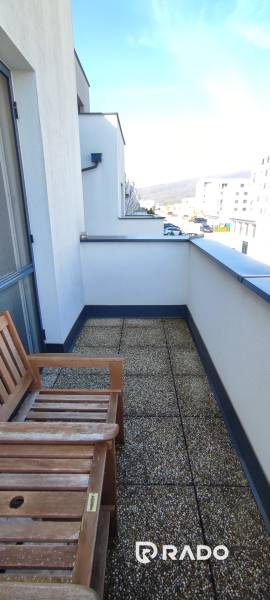 Balcony with a bench in a 2-room apartment on Predmerského Street, Trenčín, with a view of the city.