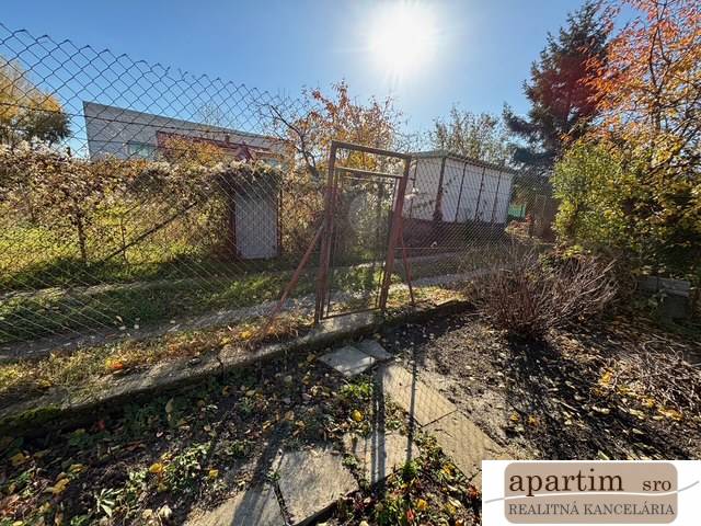Gardens on Stredná Street in Bratislava-Ružinov with a fence and greenery.