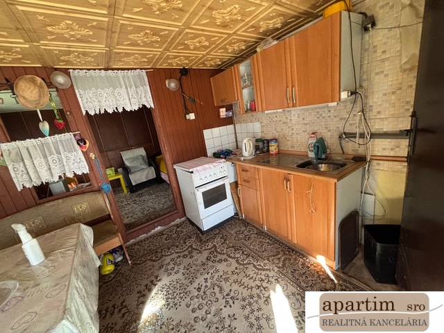 A kitchen with wooden decor, a sofa, and a carpet in the Gardens.