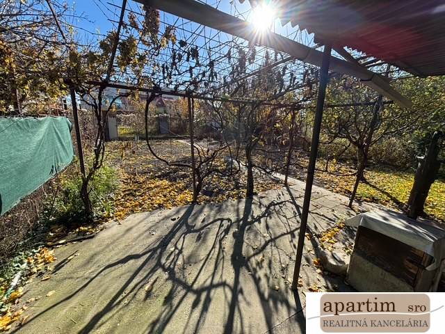 Autumn garden in Bratislava - Ružinov on Stredná Street with a pergola and fallen leaves.