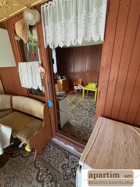 Interior of a cottage in Záhrady with wooden paneling and carpet.