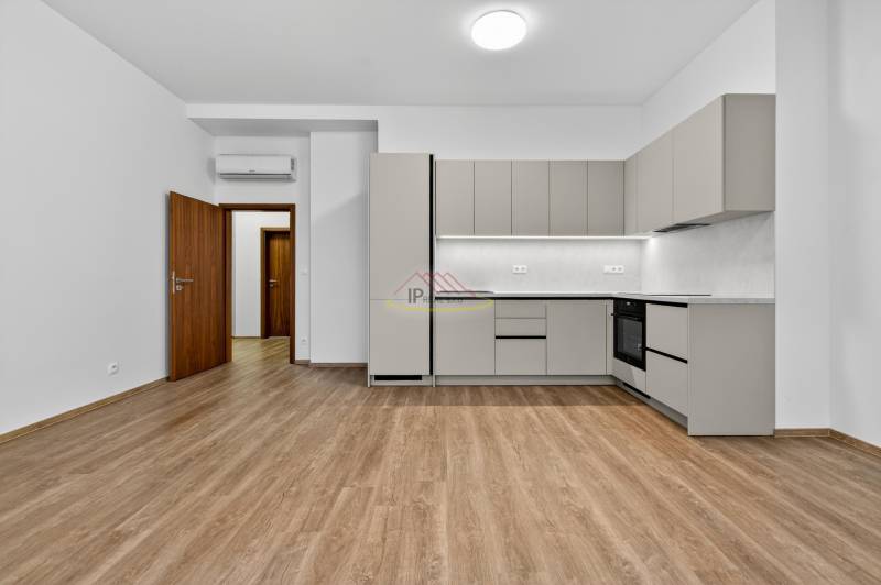 A kitchen in a 4-room apartment with a wooden decor floor and a gray kitchen unit.