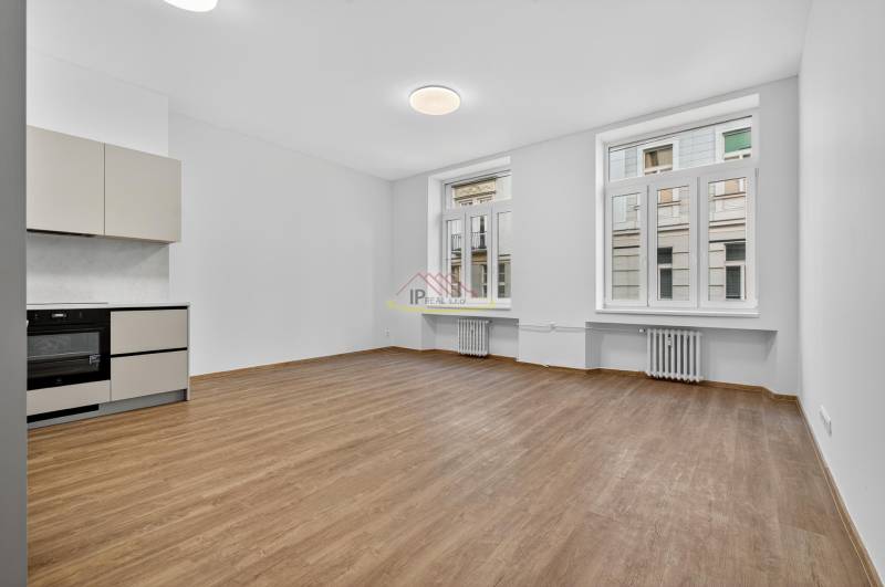 A kitchen in a 4-room apartment with a wooden decor floor and light walls.
