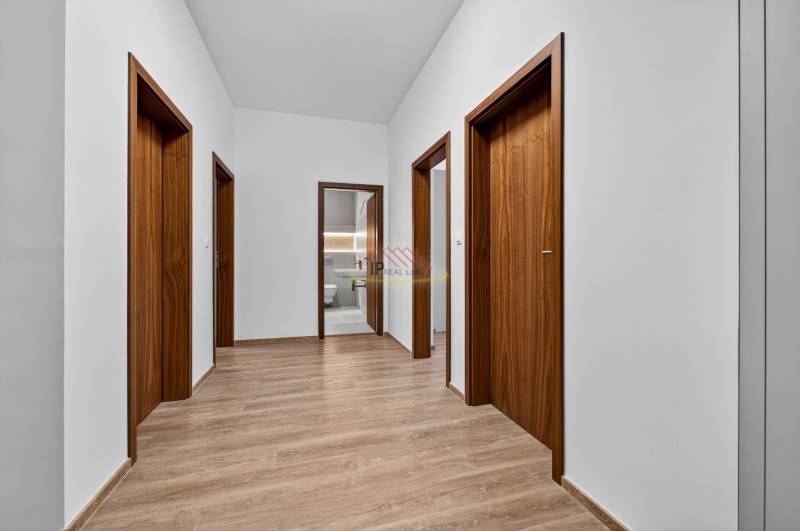A hallway in a 4-room apartment with doors and flooring featuring a wood decor.