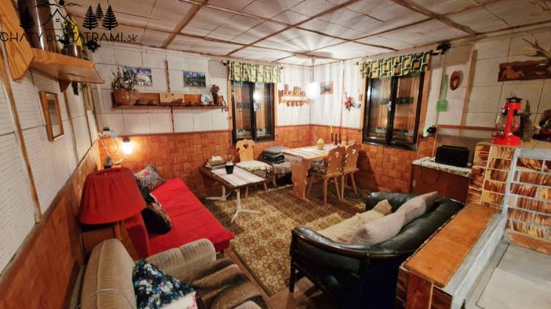 Rustic interior of a cottage with sofas, wooden decor, and decorations in a cozy atmosphere.