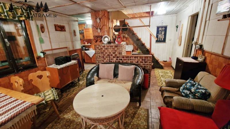 A cottage with rustic furniture and comfortable seating, floor with wooden decor.