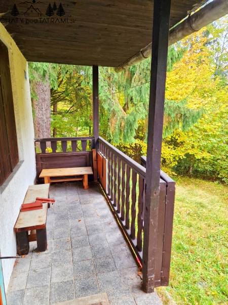 A wooden balcony of a cottage with a view of greenery in Tále in Bystrá.