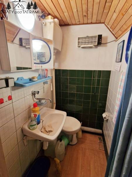 A bathroom in a cabin with a sink, toilet, and floor with a wood decor.