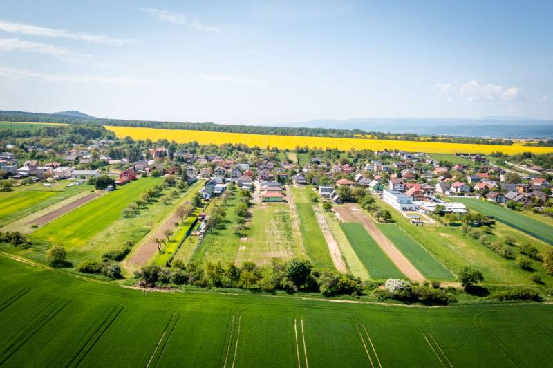 Aerial view of Vyšná Šebastová street with vast fields and family houses in the countryside.