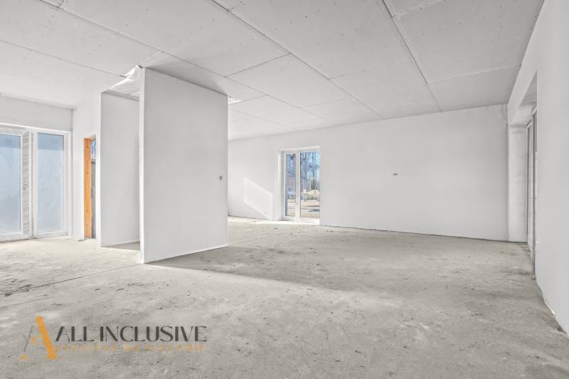 An empty interior in a family house with white walls and large windows.
