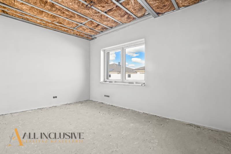 Raw room in a family house with a window and an insulated ceiling.