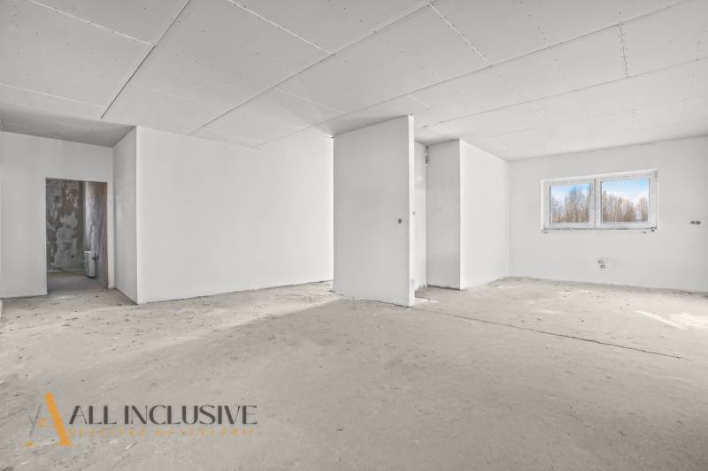 A bright room in a family house with a plasterboard ceiling and a large window.