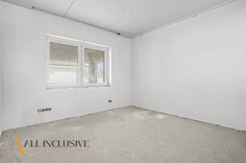 A construction room in a family house with a window and an unfinished floor, ready for completion.