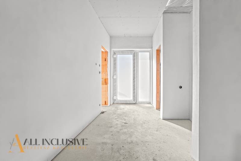 A bright hallway in a family house with two open doors and frosted glass.