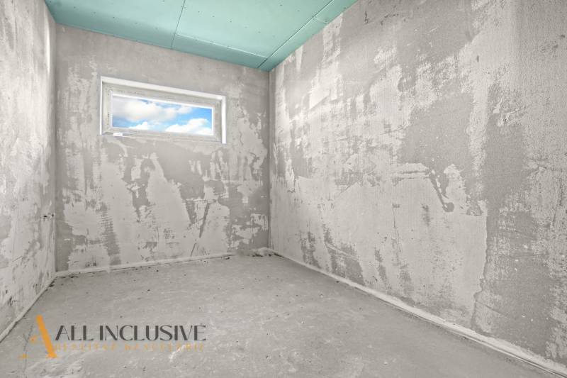 A rough construction of a room in a family house with a window and unfinished walls.