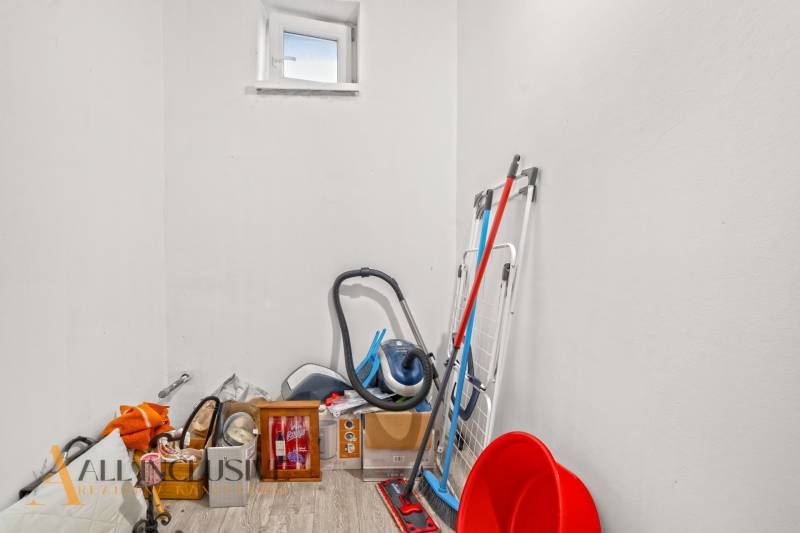 Storage space with cleaning supplies and a wooden decor floor in a family house.