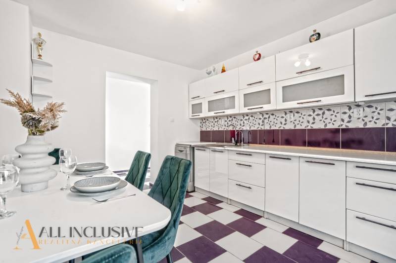 A kitchen in a family house with built-in appliances and geometric tiles.
