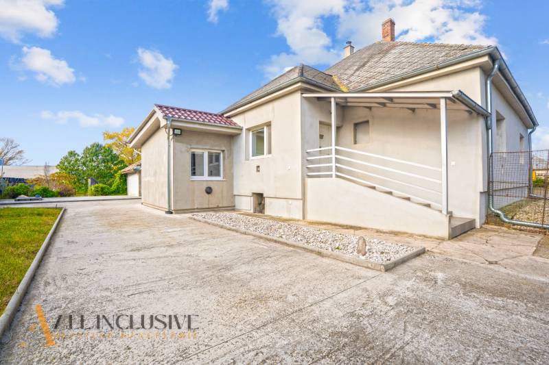 A family house in Veľké Kosihy with a sloped roof and a paved courtyard.