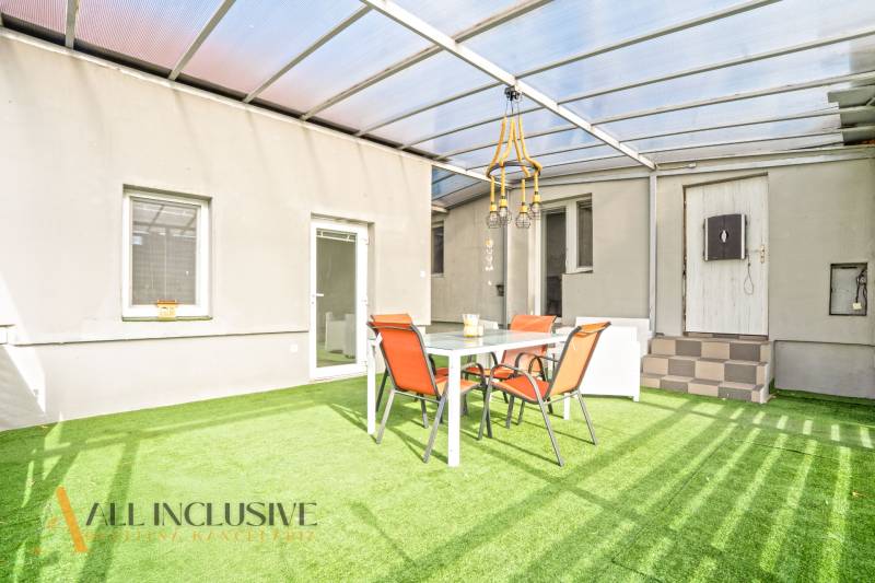 The terrace of a family house in Veľké Kosihy with artificial grass and garden furniture.