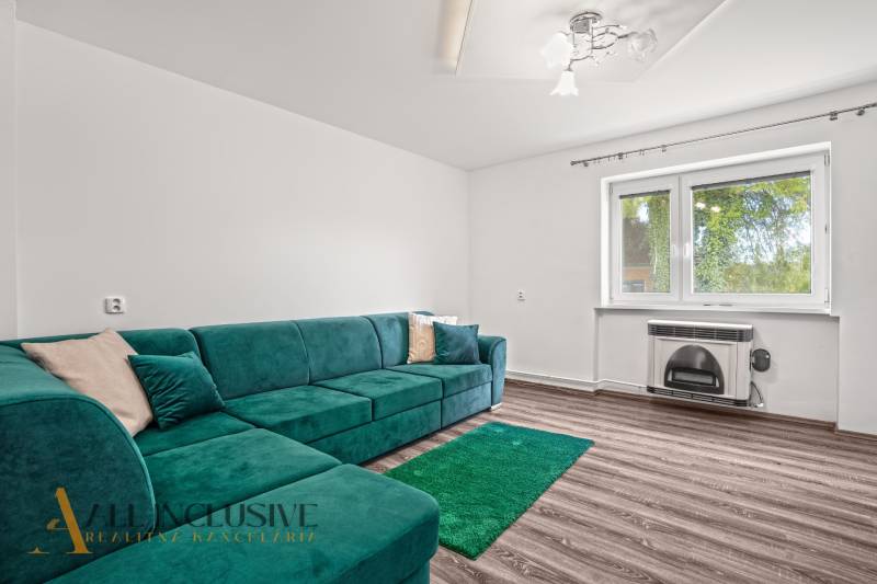 Living room in a family house with a turquoise sofa and a wooden decor floor.